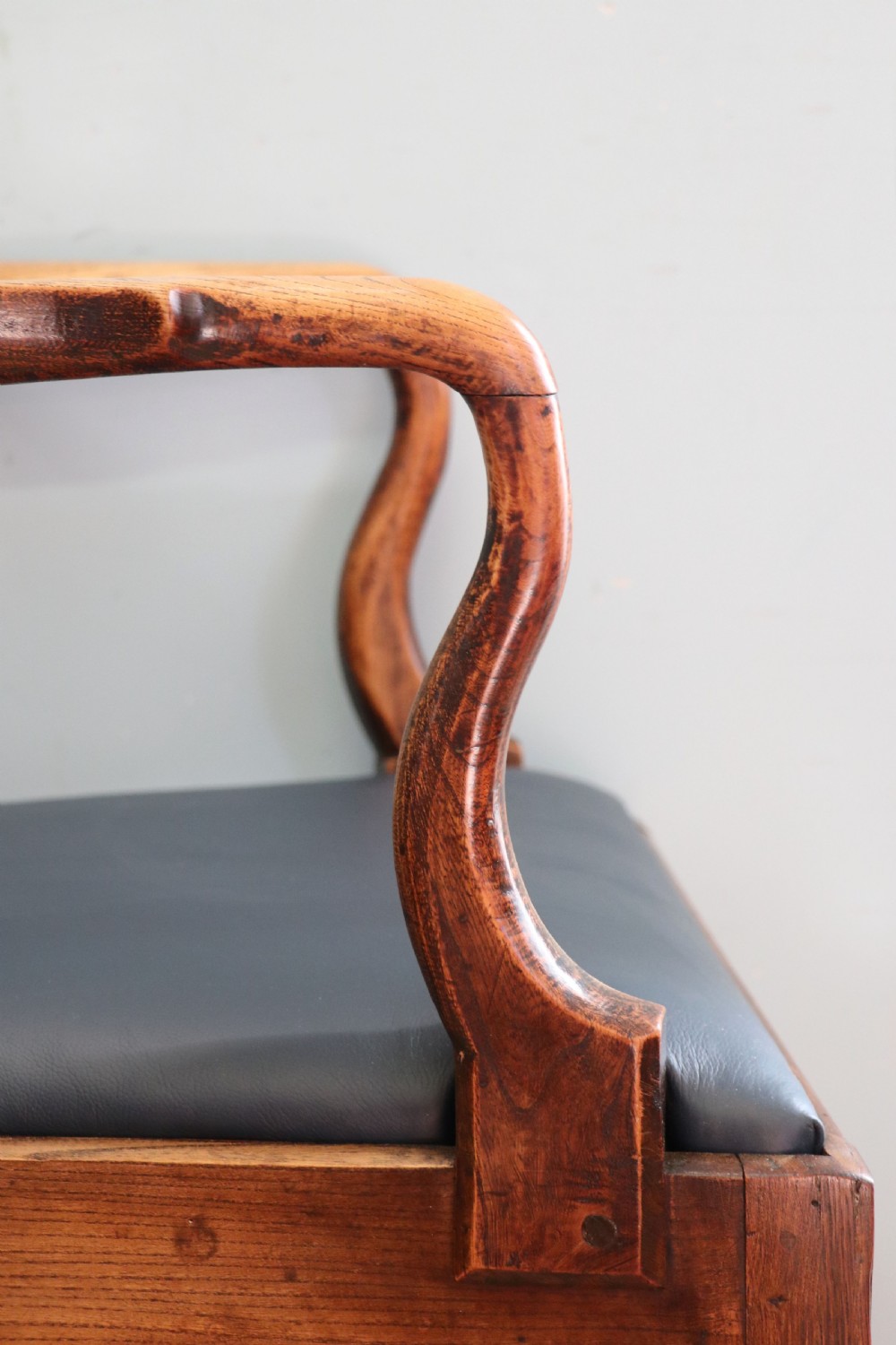 A pair of early 19th century dark timber carver chairs featuring open pierced splats, swept armrests, and dark upholstered seats. View XV