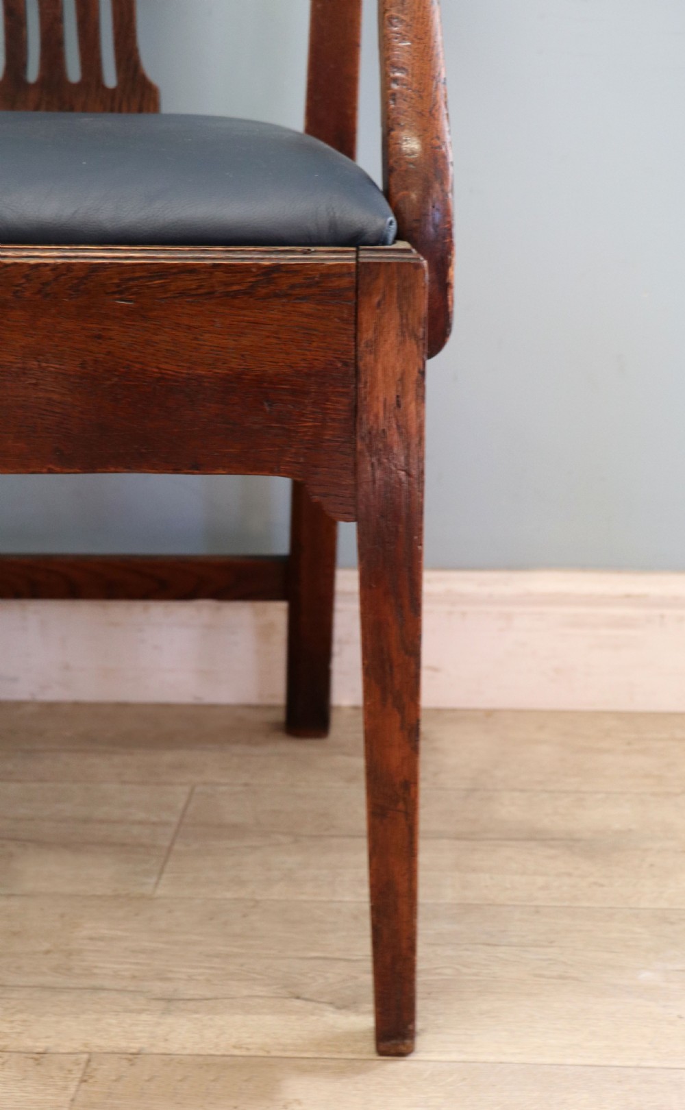 A pair of early 19th century dark timber carver chairs featuring open pierced splats, swept armrests, and dark upholstered seats. View XVI