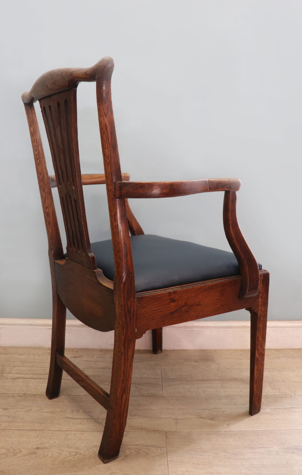A pair of early 19th century dark timber carver chairs featuring open pierced splats, swept armrests, and dark upholstered seats. View XVII