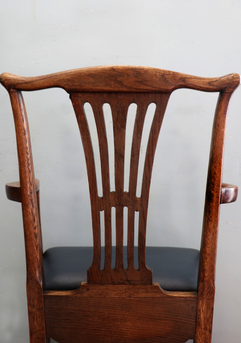 A pair of early 19th century dark timber carver chairs featuring open pierced splats, swept armrests, and dark upholstered seats. View XXI