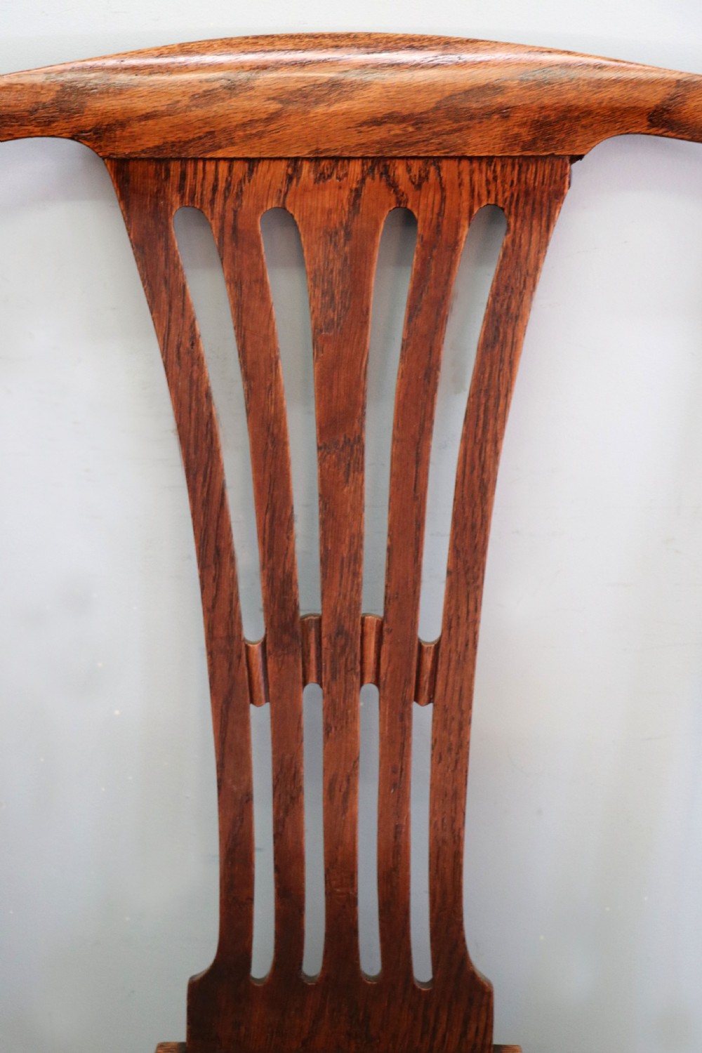 A pair of early 19th century dark timber carver chairs featuring open pierced splats, swept armrests, and dark upholstered seats. View XXII