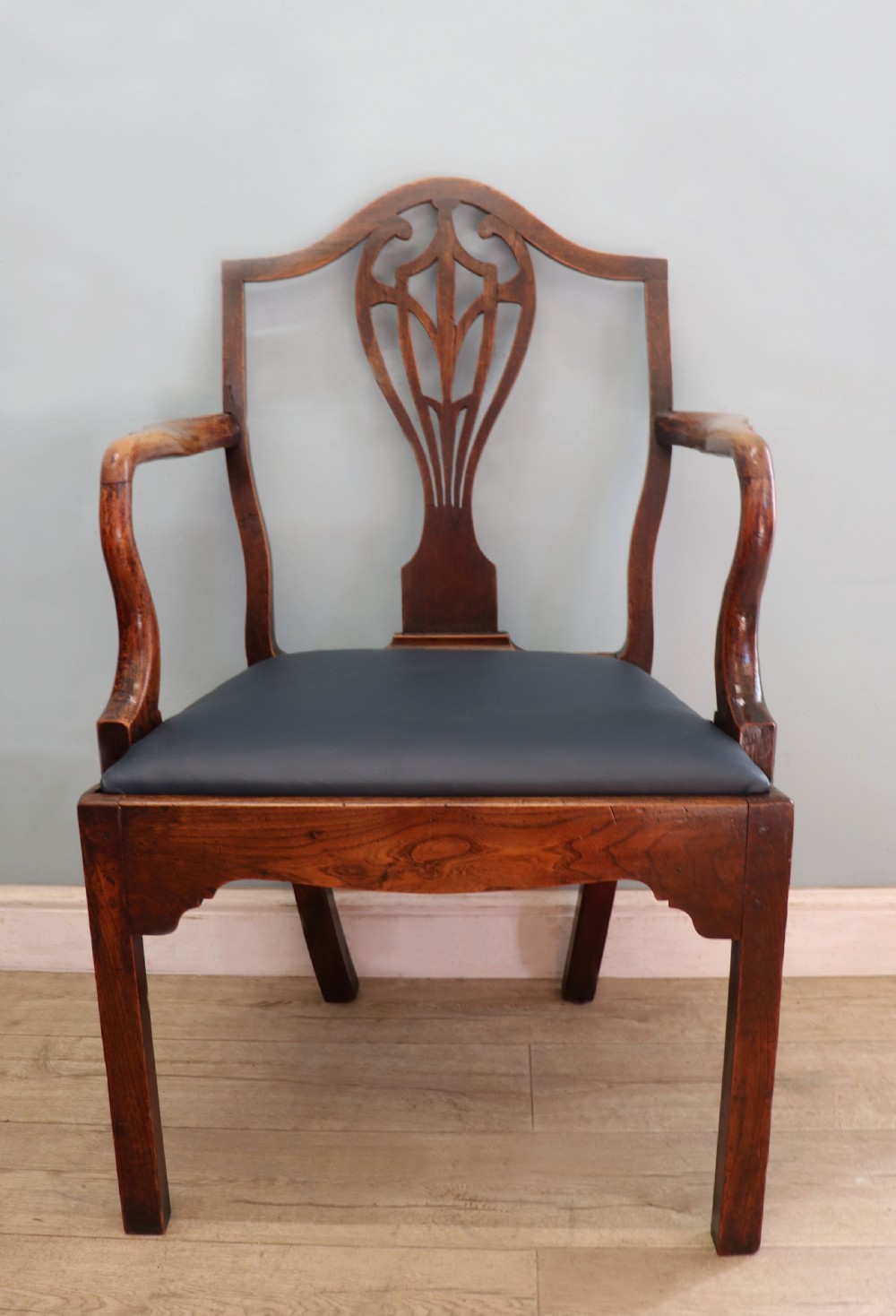 A pair of early 19th century dark timber carver chairs featuring open pierced splats, swept armrests, and dark upholstered seats. View XXIV
