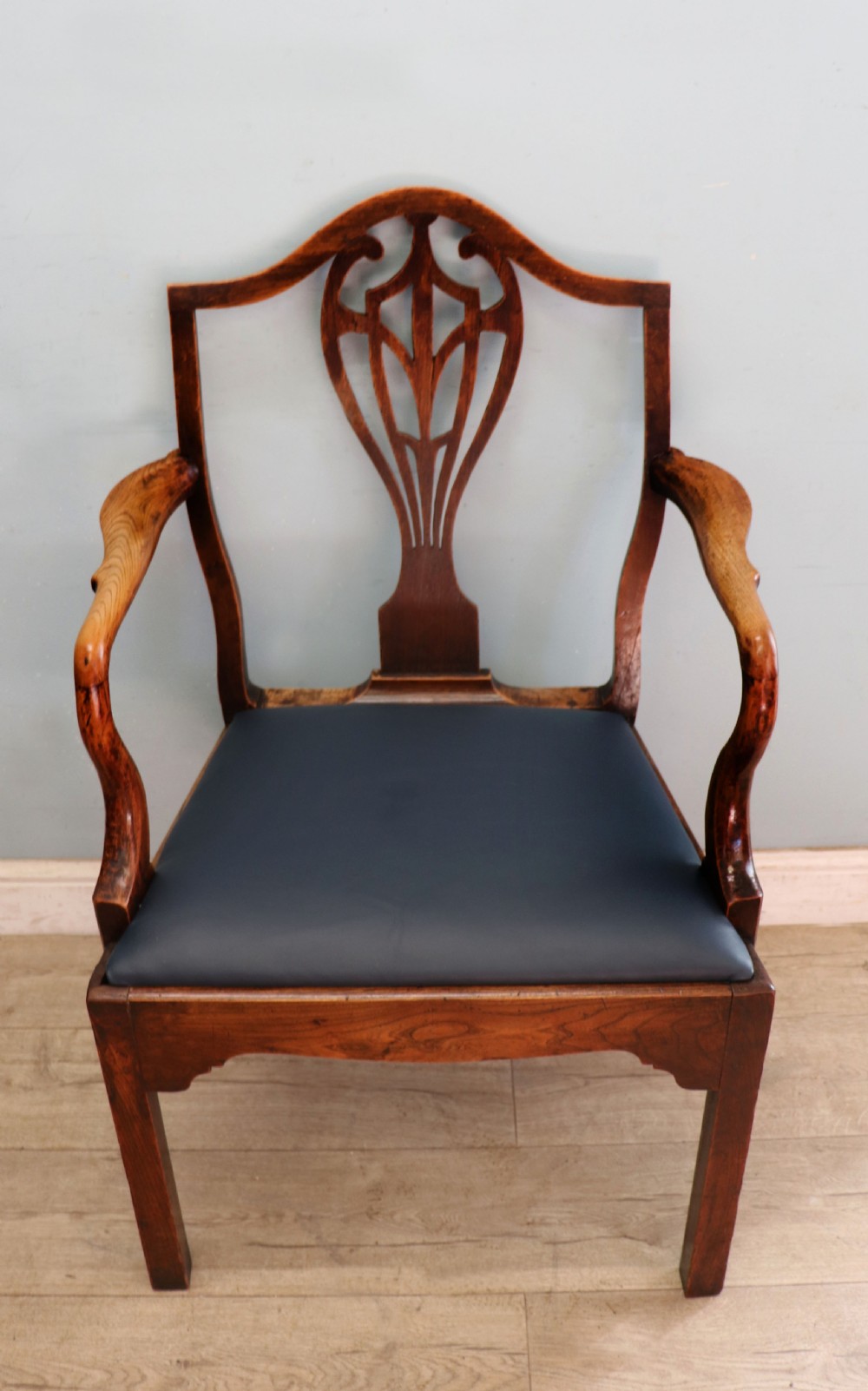 A pair of early 19th century dark timber carver chairs featuring open pierced splats, swept armrests, and dark upholstered seats. View XXV