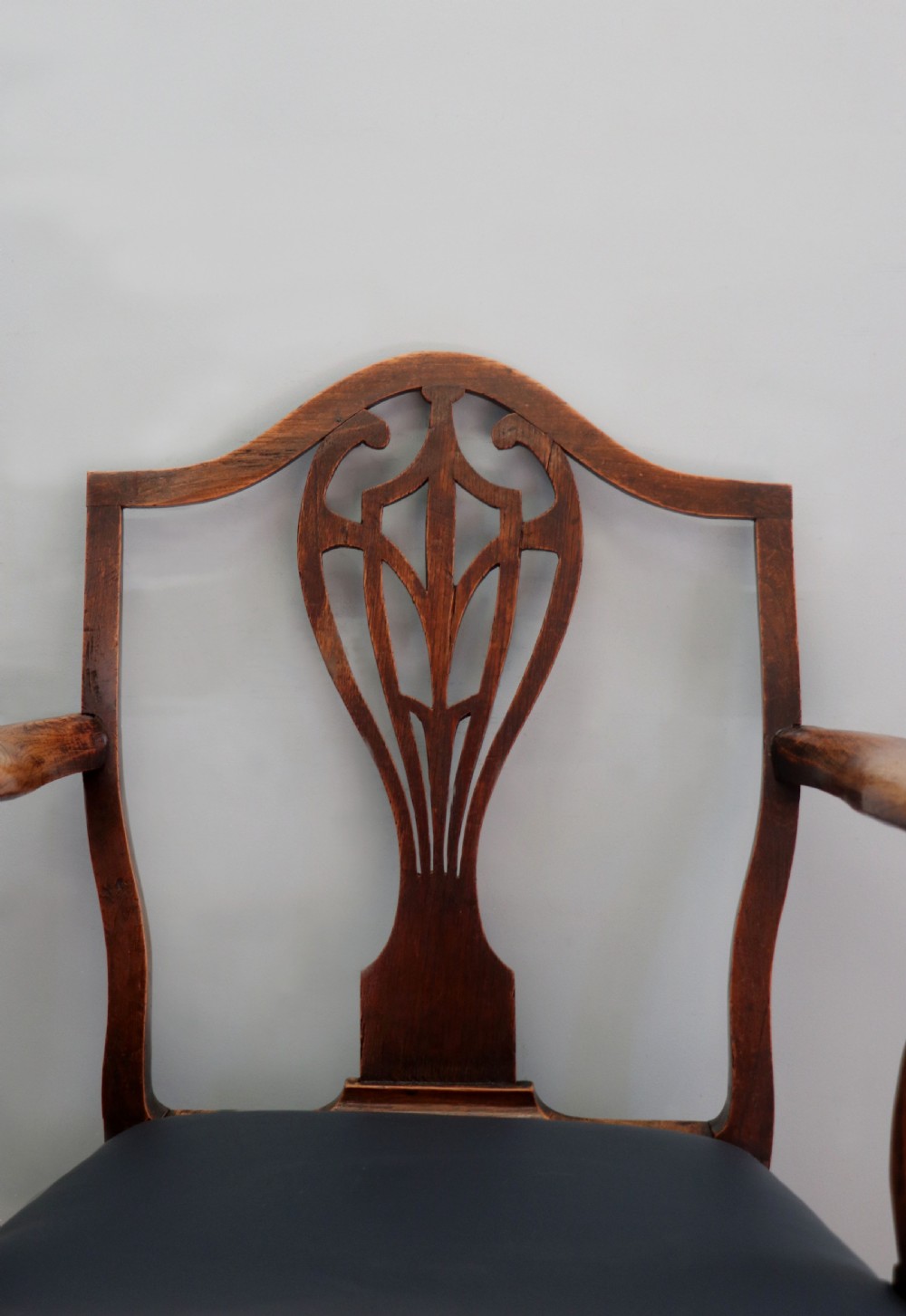 A pair of early 19th century dark timber carver chairs featuring open pierced splats, swept armrests, and dark upholstered seats. View XXVI