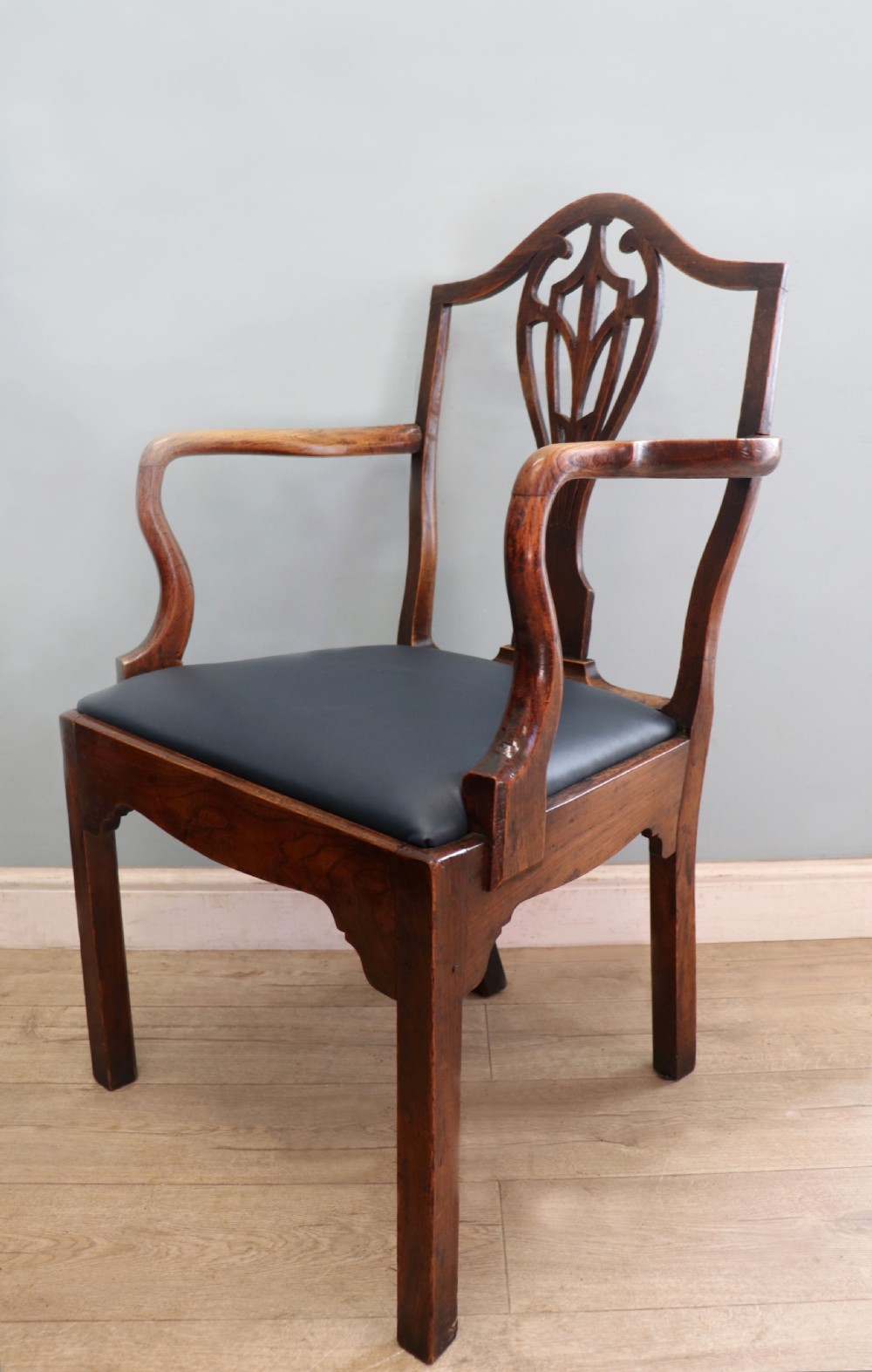A pair of early 19th century dark timber carver chairs featuring open pierced splats, swept armrests, and dark upholstered seats. View XXVII