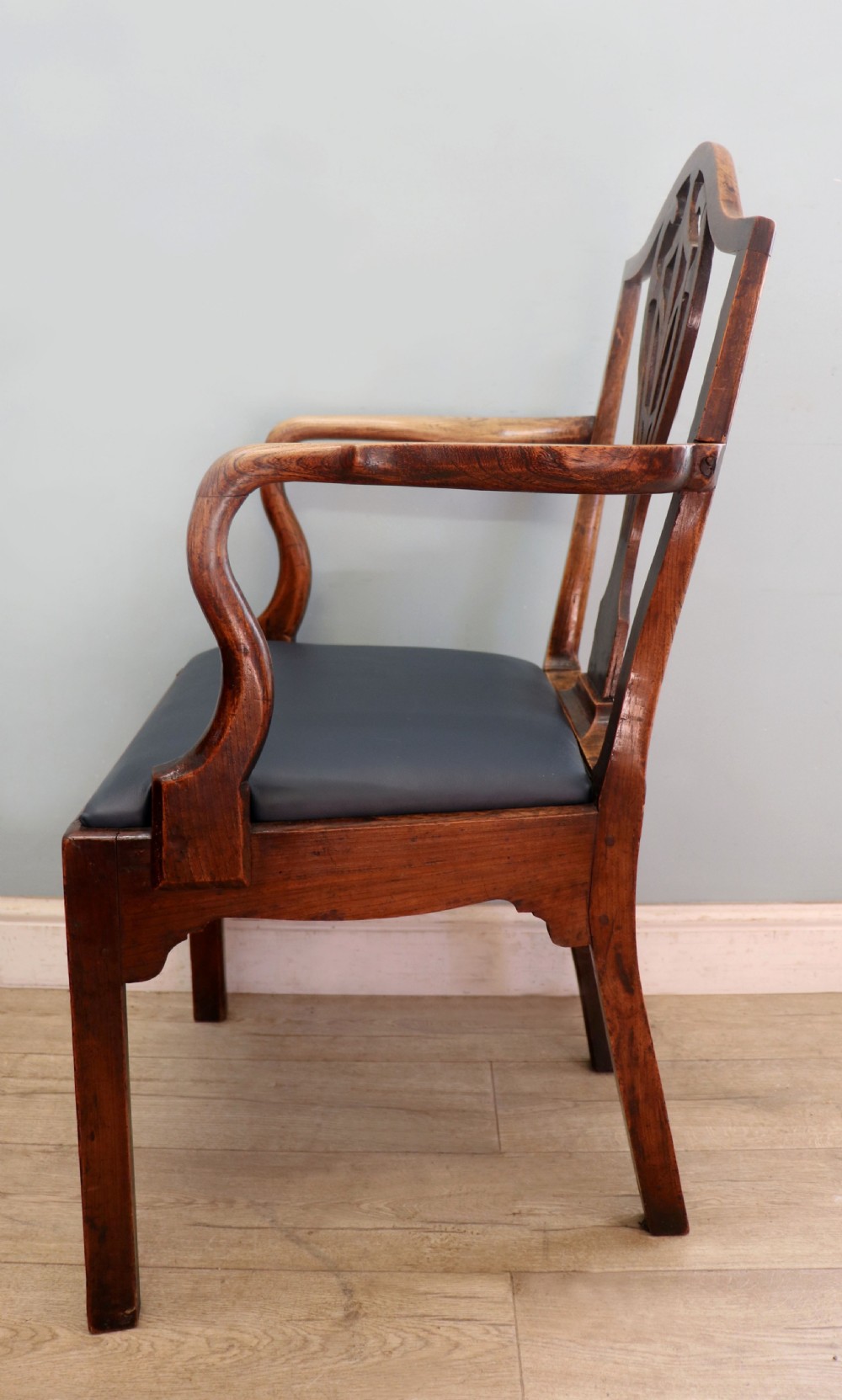 A pair of early 19th century dark timber carver chairs featuring open pierced splats, swept armrests, and dark upholstered seats. View XXVIII