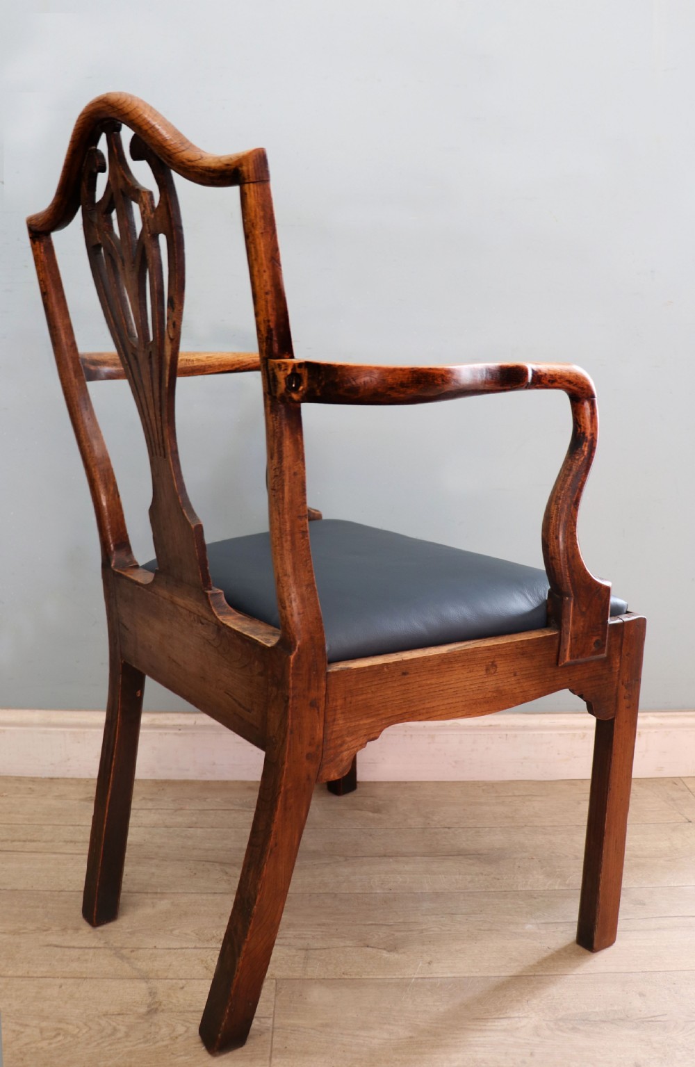 A pair of early 19th century dark timber carver chairs featuring open pierced splats, swept armrests, and dark upholstered seats. View XXX