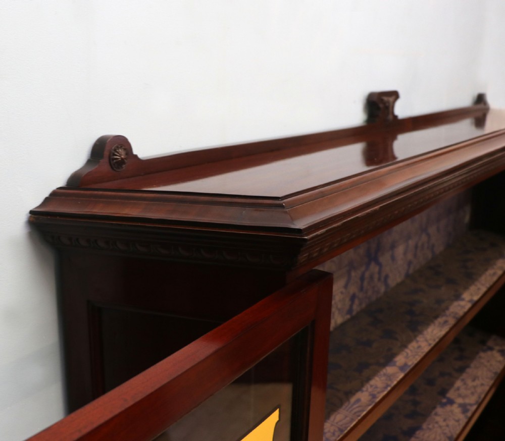 A late nineteenth-century dark mahogany display cabinet featuring two glazed doors adorned with hand-painted gold advertising typography, resting on short cabriole legs. View XII