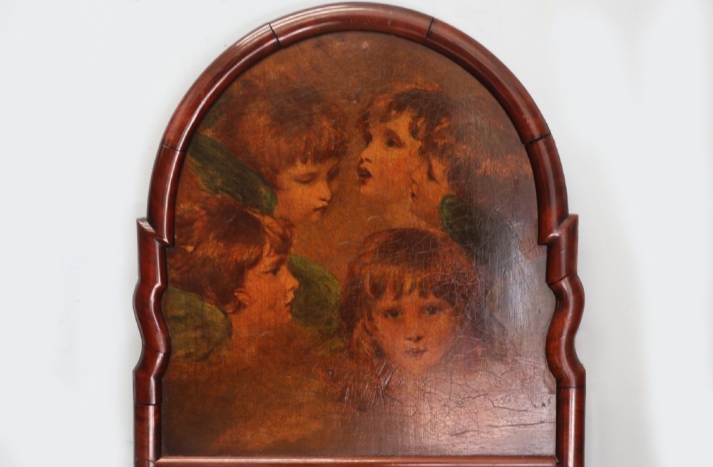 A tall, arched 19th-century mahogany wall mirror featuring an upper oil painting of childrens faces above a rectangular mirror glass. View V