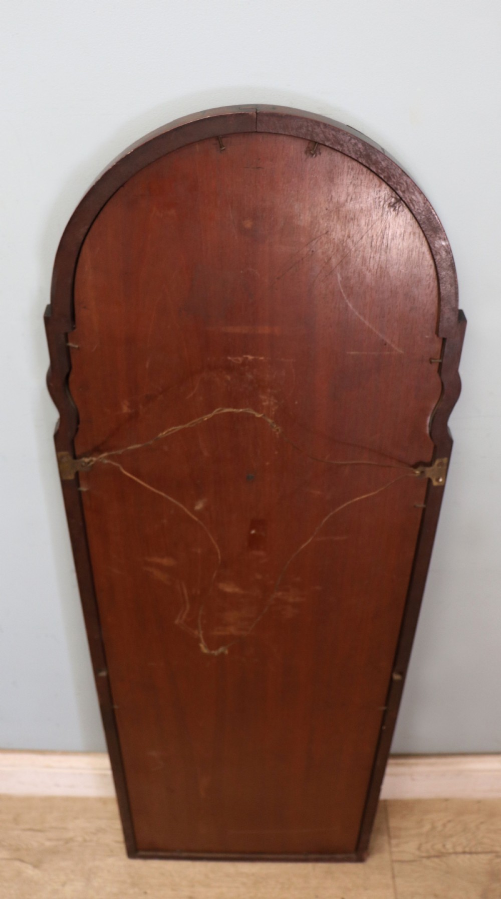 A tall, arched 19th-century mahogany wall mirror featuring an upper oil painting of childrens faces above a rectangular mirror glass. View XI