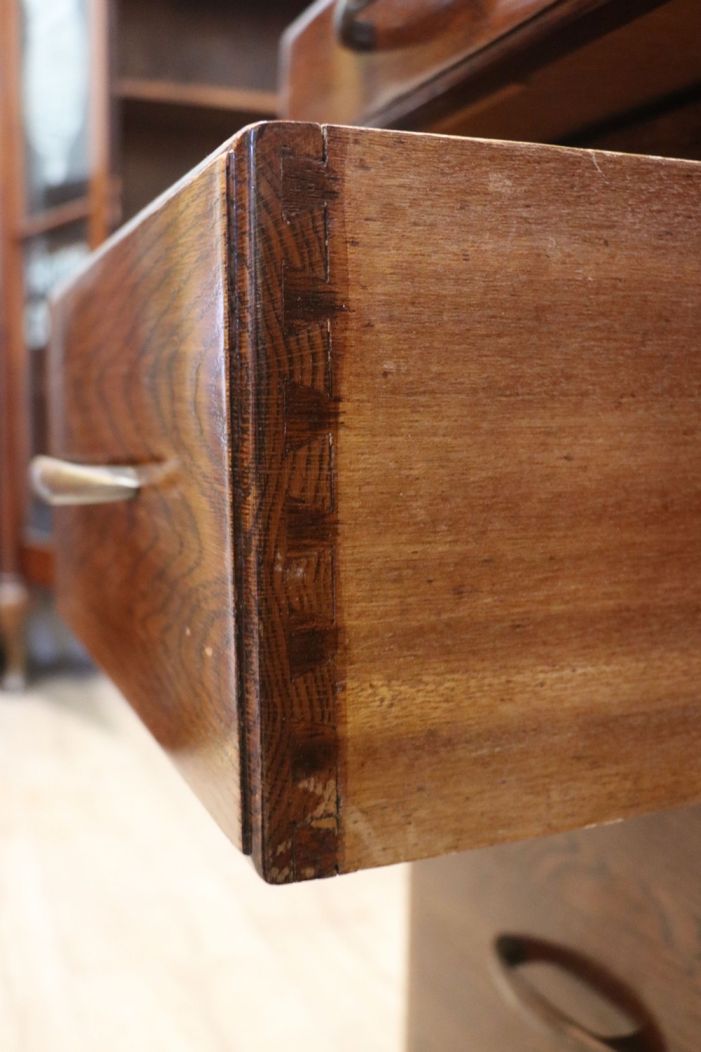 A twin-pedestal mid-century oak office desk featuring seven drawers with brass pull handles and a dark plinth base. View XIV