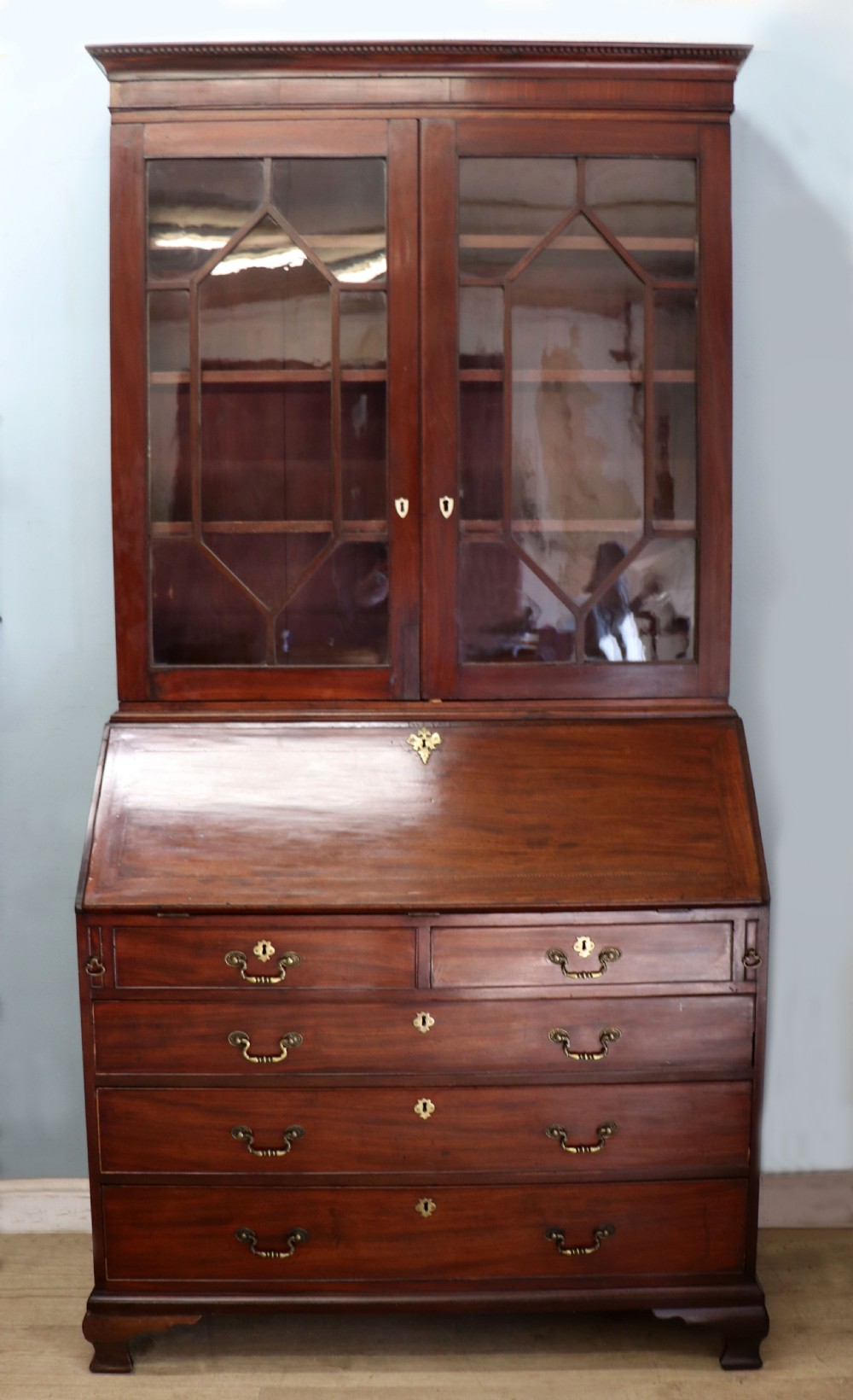 Late eighteenth-century mahogany bureau bookcase with an upper glazed cabinet featuring geometric astragal bars, an open fall-front writing surface, and lower drawers with brass handles. View III