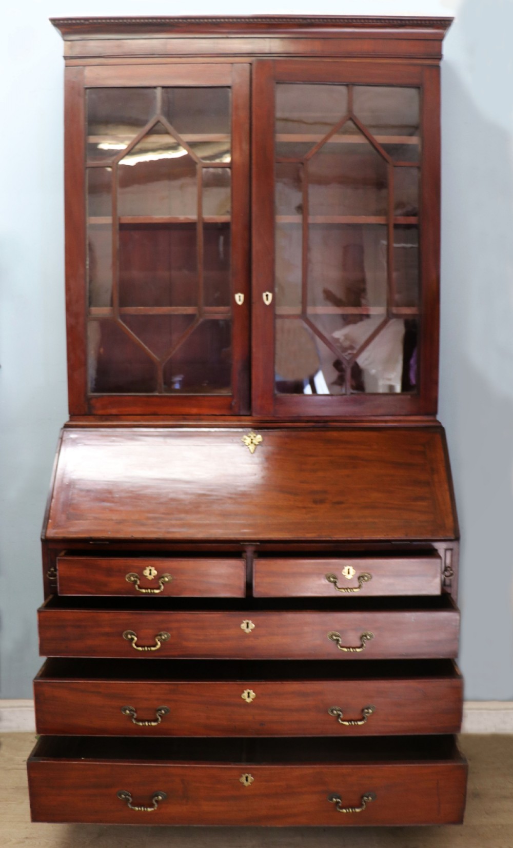 Late eighteenth-century mahogany bureau bookcase with an upper glazed cabinet featuring geometric astragal bars, an open fall-front writing surface, and lower drawers with brass handles. View V