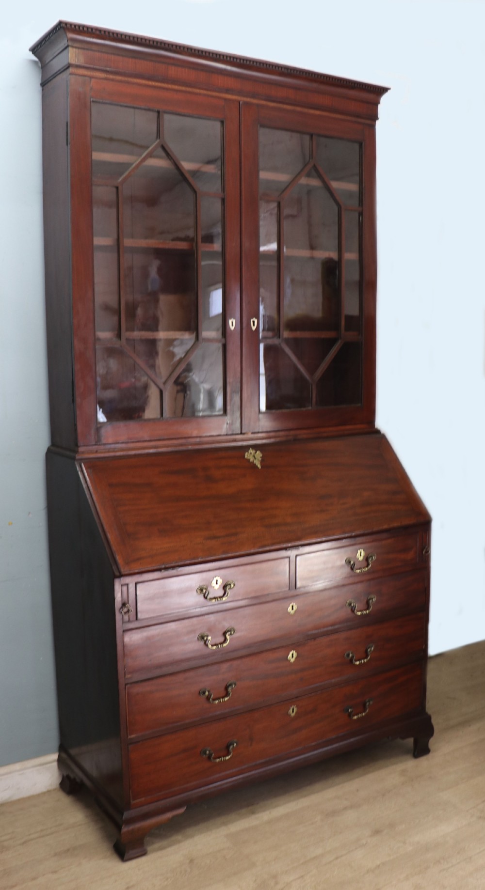 Late eighteenth-century mahogany bureau bookcase with an upper glazed cabinet featuring geometric astragal bars, an open fall-front writing surface, and lower drawers with brass handles. View VI
