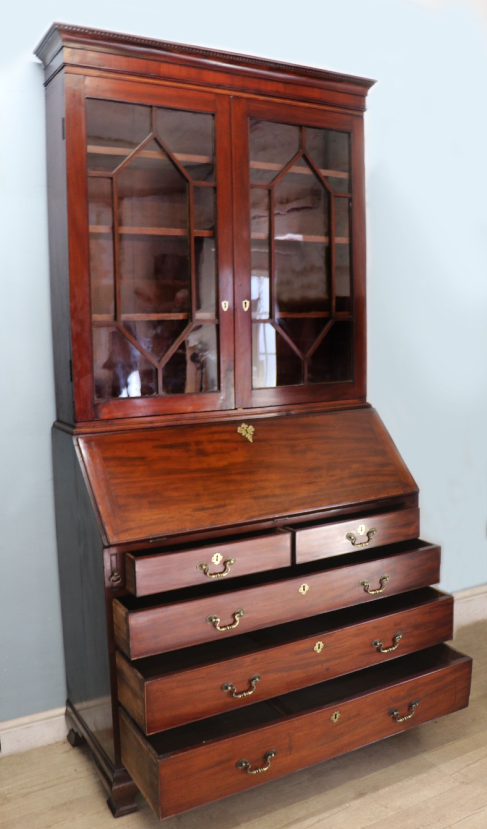 Late eighteenth-century mahogany bureau bookcase with an upper glazed cabinet featuring geometric astragal bars, an open fall-front writing surface, and lower drawers with brass handles. View VII