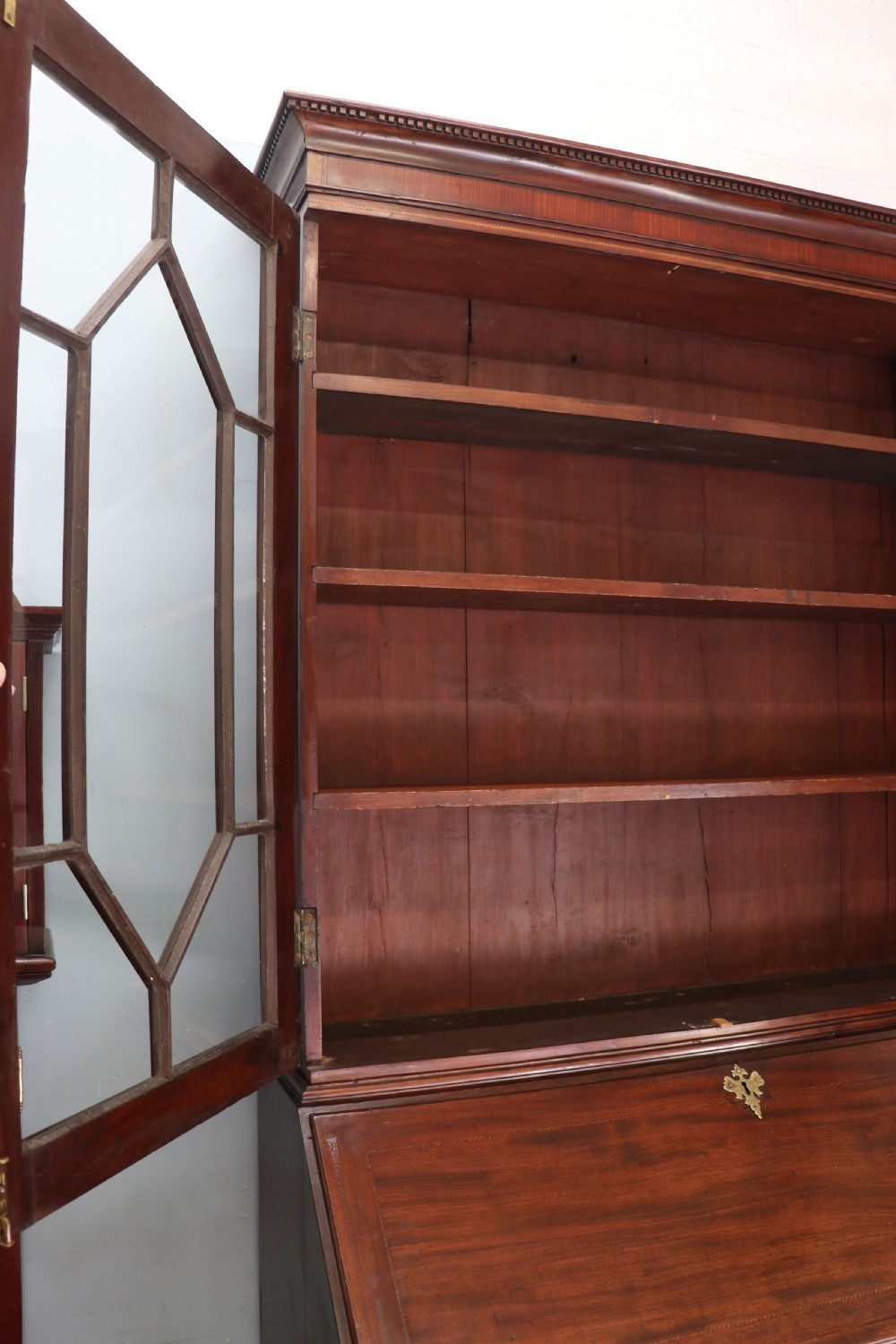 Late eighteenth-century mahogany bureau bookcase with an upper glazed cabinet featuring geometric astragal bars, an open fall-front writing surface, and lower drawers with brass handles. View X