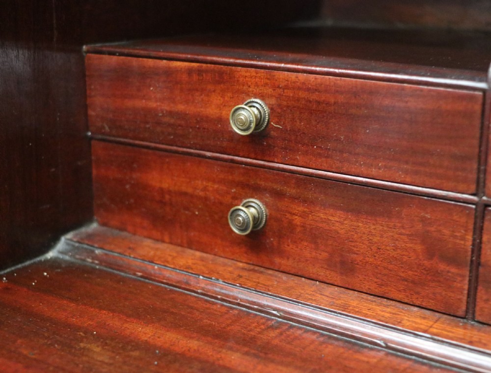Late eighteenth-century mahogany bureau bookcase with an upper glazed cabinet featuring geometric astragal bars, an open fall-front writing surface, and lower drawers with brass handles. View XXIV