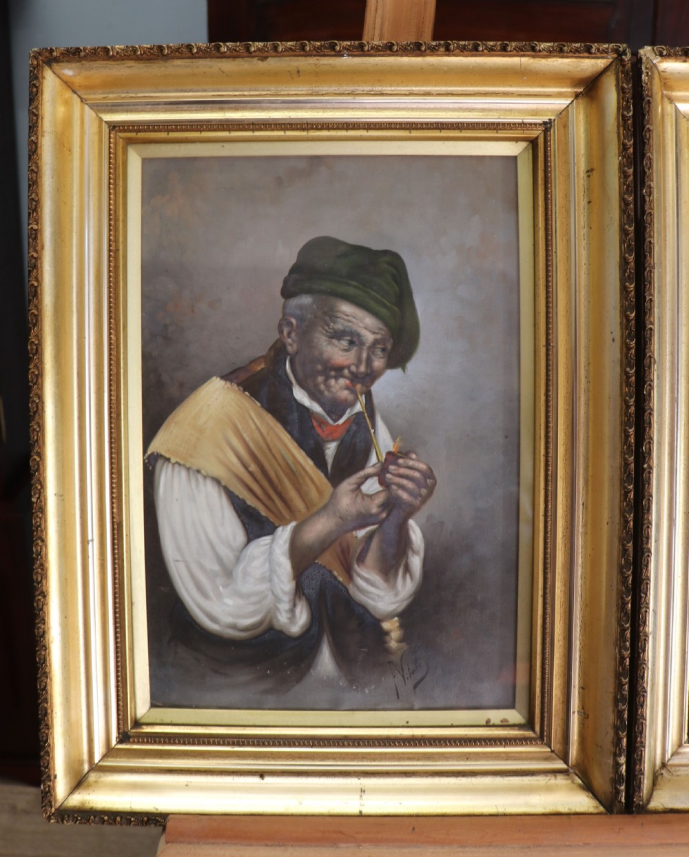 A pair of framed Italian oil portraits depicting an elderly man smoking a pipe and an elderly woman wearing a blue headscarf, both set in matching giltwood frames. View IV