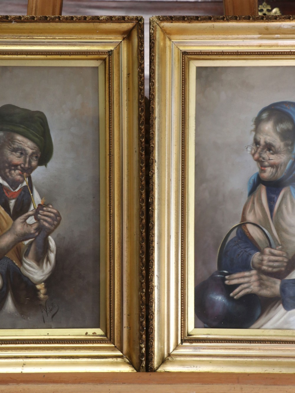 A pair of framed Italian oil portraits depicting an elderly man smoking a pipe and an elderly woman wearing a blue headscarf, both set in matching giltwood frames. View XV