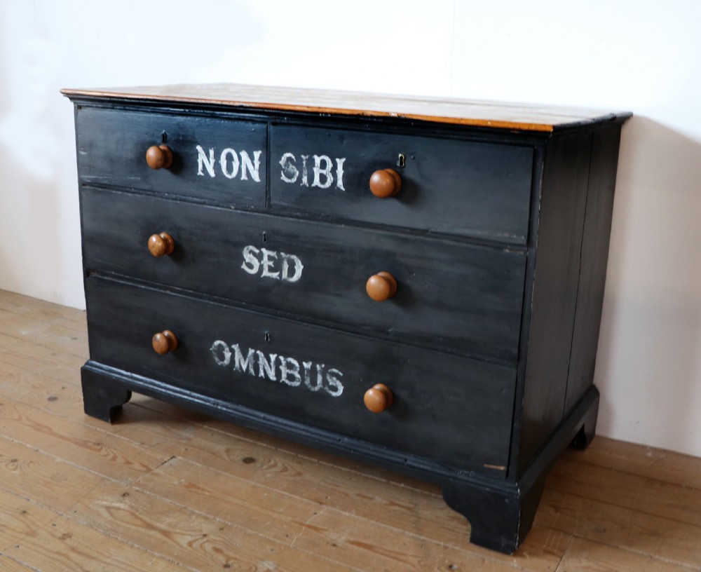 A Victorian black painted pine chest of drawers featuring a natural timber top with hand-painted lettering and turned wooden knobs. View IV