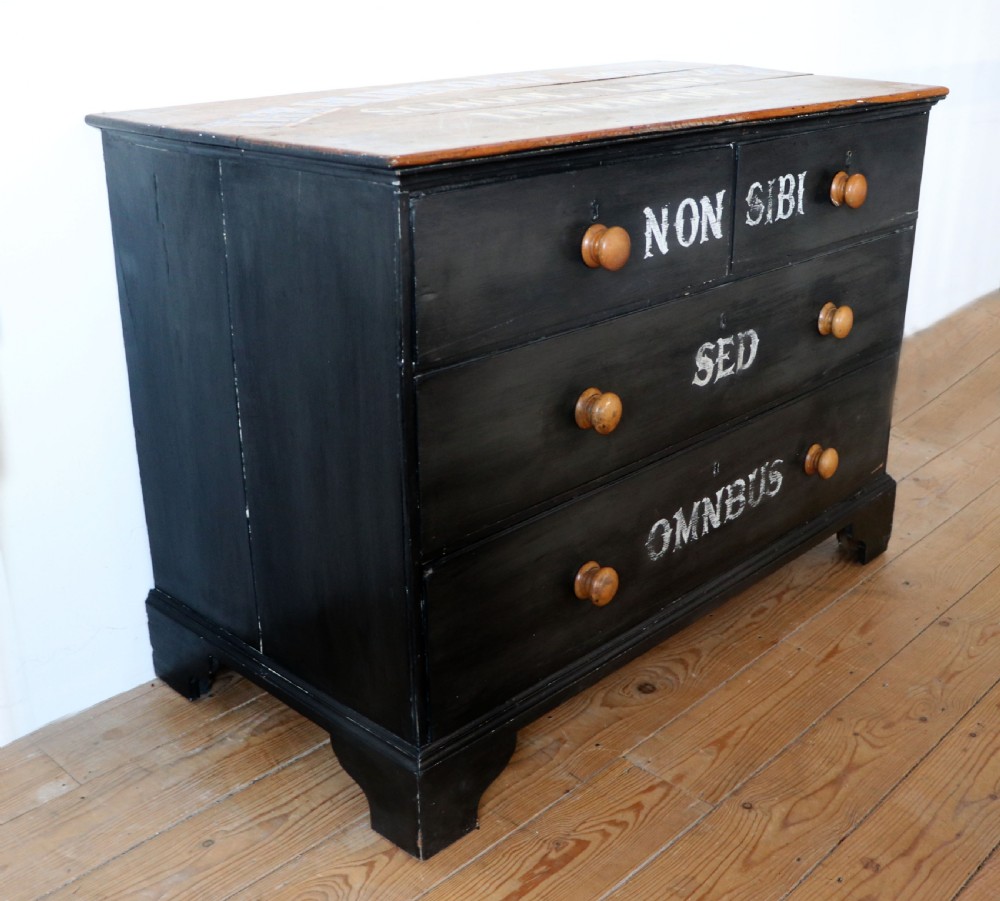 A Victorian black painted pine chest of drawers featuring a natural timber top with hand-painted lettering and turned wooden knobs. View V