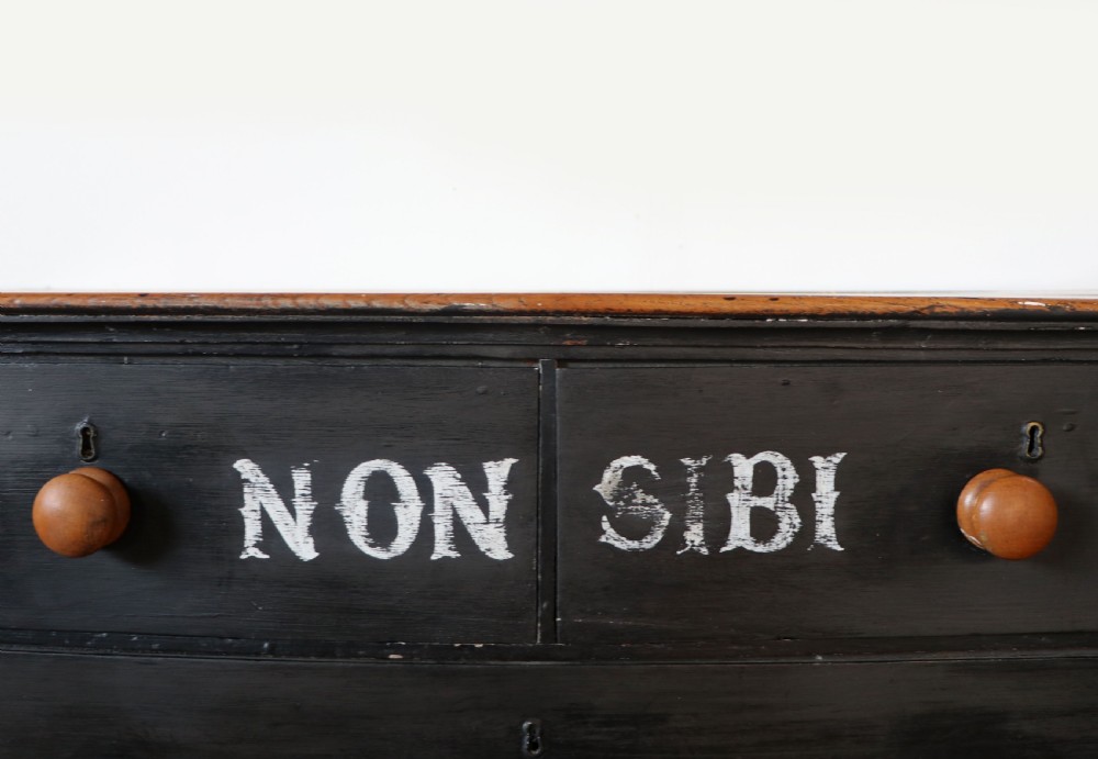 A Victorian black painted pine chest of drawers featuring a natural timber top with hand-painted lettering and turned wooden knobs. View X