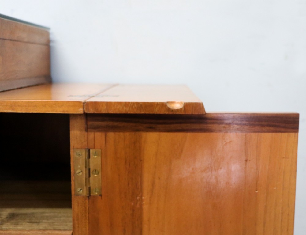 An Art Deco walnut pedestal desk featuring a glass-topped centre writing surface and hinged fold-out side flaps supported by twin cabinet bases. View XVIII
