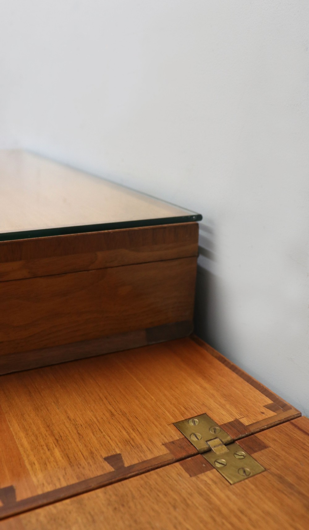 An Art Deco walnut pedestal desk featuring a glass-topped centre writing surface and hinged fold-out side flaps supported by twin cabinet bases. View XX