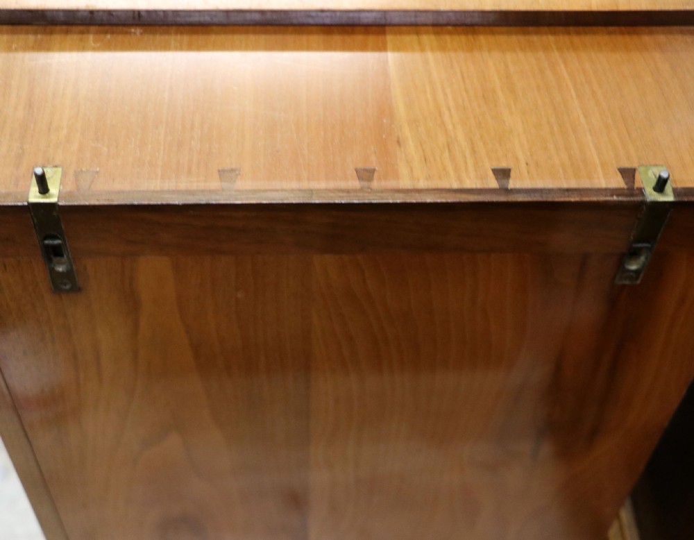 An Art Deco walnut pedestal desk featuring a glass-topped centre writing surface and hinged fold-out side flaps supported by twin cabinet bases. View XXVII