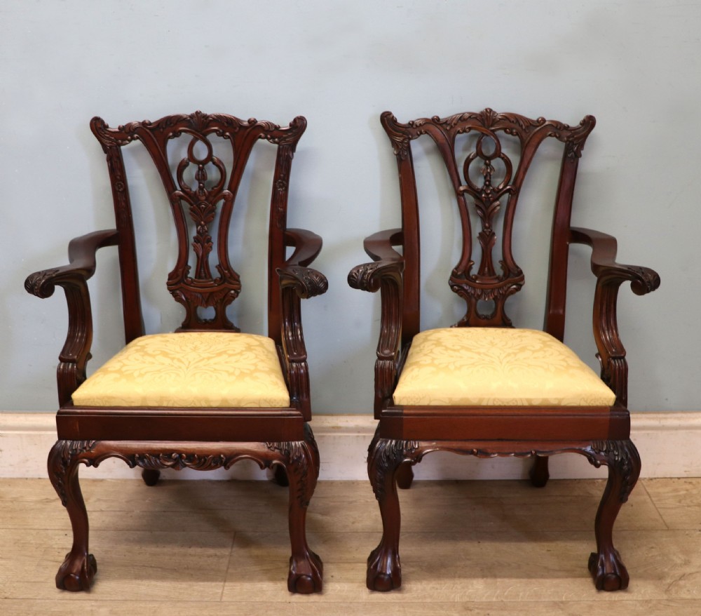 A pair of Georgian revival style child carver chairs made of polished dark mahogany with pierced splat backs, cabriole legs, ball and claw feet, and yellow damask upholstered seats. View II
