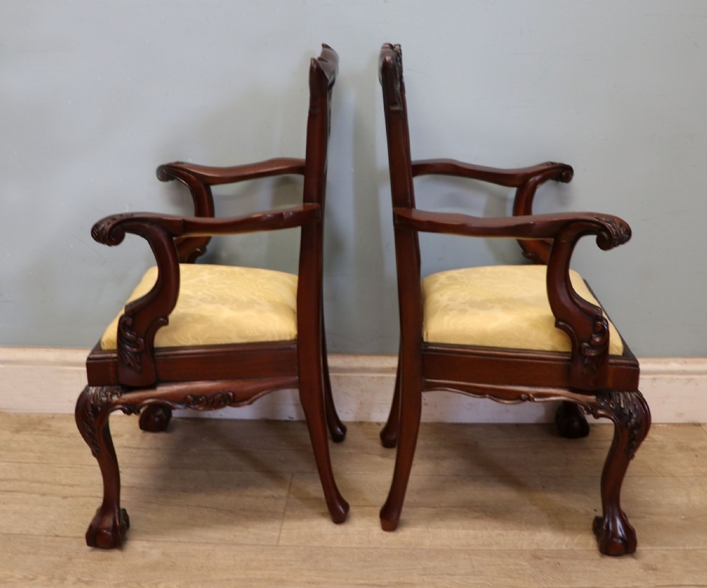 A pair of Georgian revival style child carver chairs made of polished dark mahogany with pierced splat backs, cabriole legs, ball and claw feet, and yellow damask upholstered seats. View IV