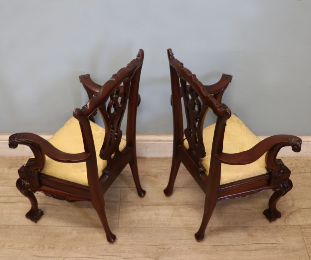 A pair of Georgian revival style child carver chairs made of polished dark mahogany with pierced splat backs, cabriole legs, ball and claw feet, and yellow damask upholstered seats. View VI