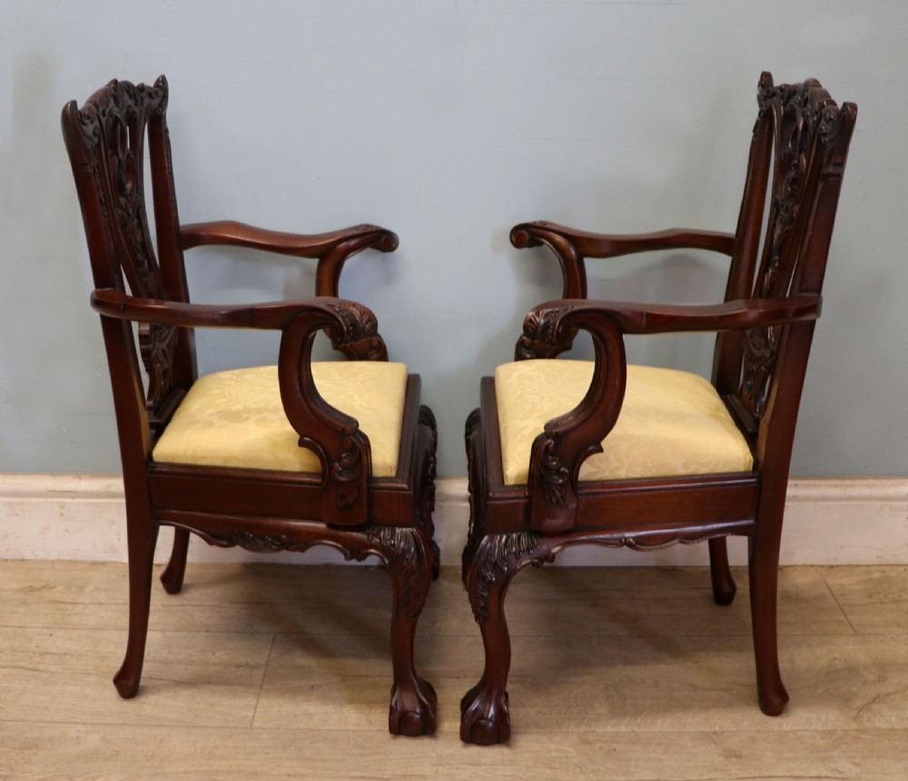 A pair of Georgian revival style child carver chairs made of polished dark mahogany with pierced splat backs, cabriole legs, ball and claw feet, and yellow damask upholstered seats. View VIII