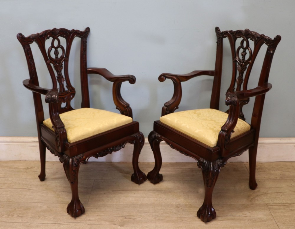 A pair of Georgian revival style child carver chairs made of polished dark mahogany with pierced splat backs, cabriole legs, ball and claw feet, and yellow damask upholstered seats. View IX