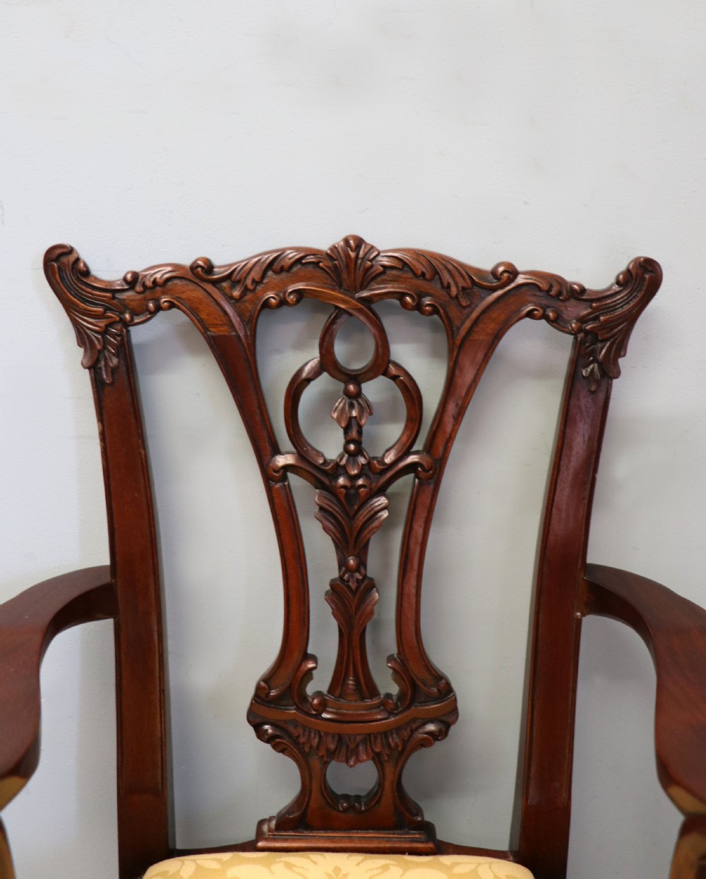 A pair of Georgian revival style child carver chairs made of polished dark mahogany with pierced splat backs, cabriole legs, ball and claw feet, and yellow damask upholstered seats. View X
