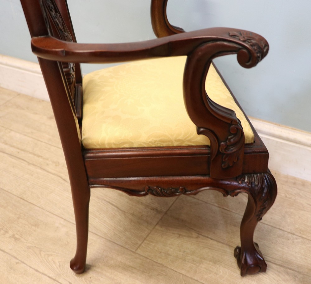 A pair of Georgian revival style child carver chairs made of polished dark mahogany with pierced splat backs, cabriole legs, ball and claw feet, and yellow damask upholstered seats. View XVI