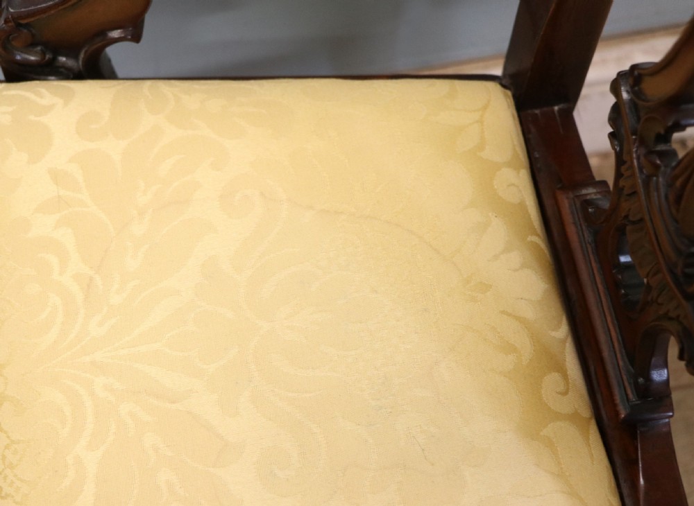 A pair of Georgian revival style child carver chairs made of polished dark mahogany with pierced splat backs, cabriole legs, ball and claw feet, and yellow damask upholstered seats. View XX
