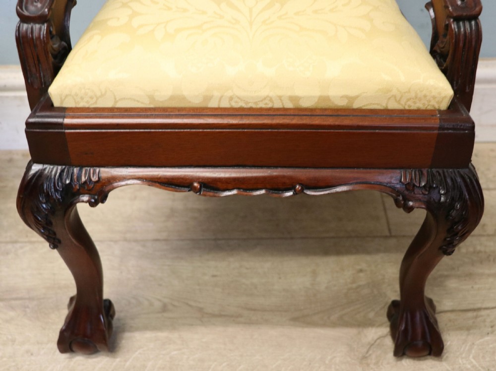 A pair of Georgian revival style child carver chairs made of polished dark mahogany with pierced splat backs, cabriole legs, ball and claw feet, and yellow damask upholstered seats. View XXI
