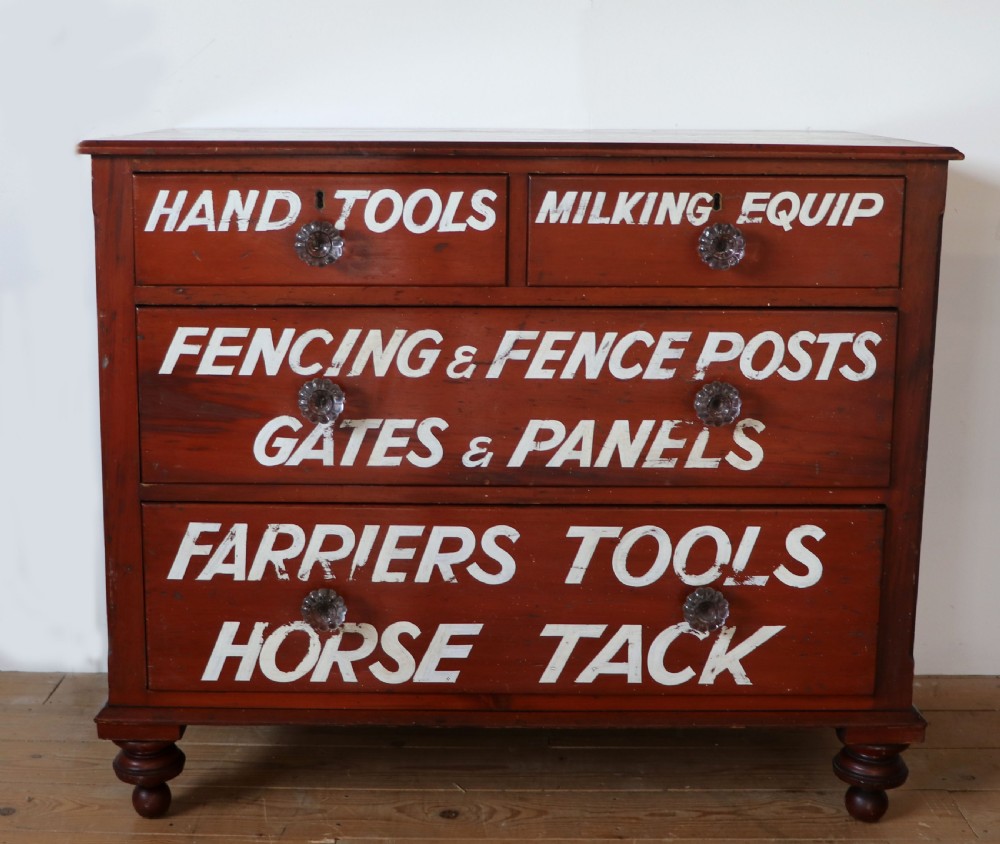 A Victorian red painted pine chest of four drawers featuring white, yellow, and green hand-painted commercial sign-writing and cut glass knobs. View II