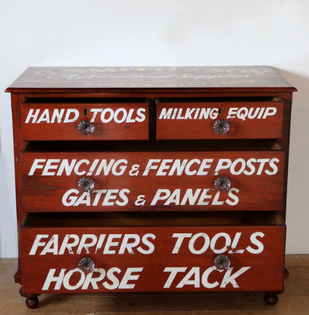 A Victorian red painted pine chest of four drawers featuring white, yellow, and green hand-painted commercial sign-writing and cut glass knobs. View III