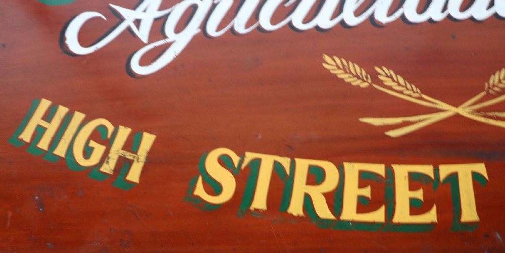 A Victorian red painted pine chest of four drawers featuring white, yellow, and green hand-painted commercial sign-writing and cut glass knobs. View XII