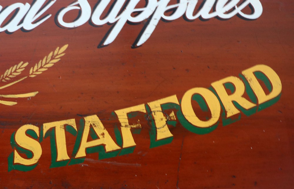 A Victorian red painted pine chest of four drawers featuring white, yellow, and green hand-painted commercial sign-writing and cut glass knobs. View XV