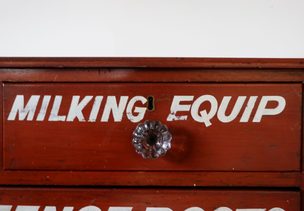A Victorian red painted pine chest of four drawers featuring white, yellow, and green hand-painted commercial sign-writing and cut glass knobs. View XVIII
