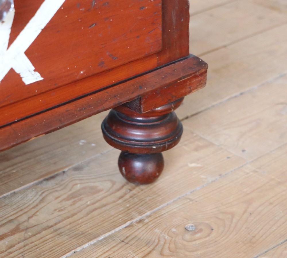 A Victorian red painted pine chest of four drawers featuring white, yellow, and green hand-painted commercial sign-writing and cut glass knobs. View XXVII