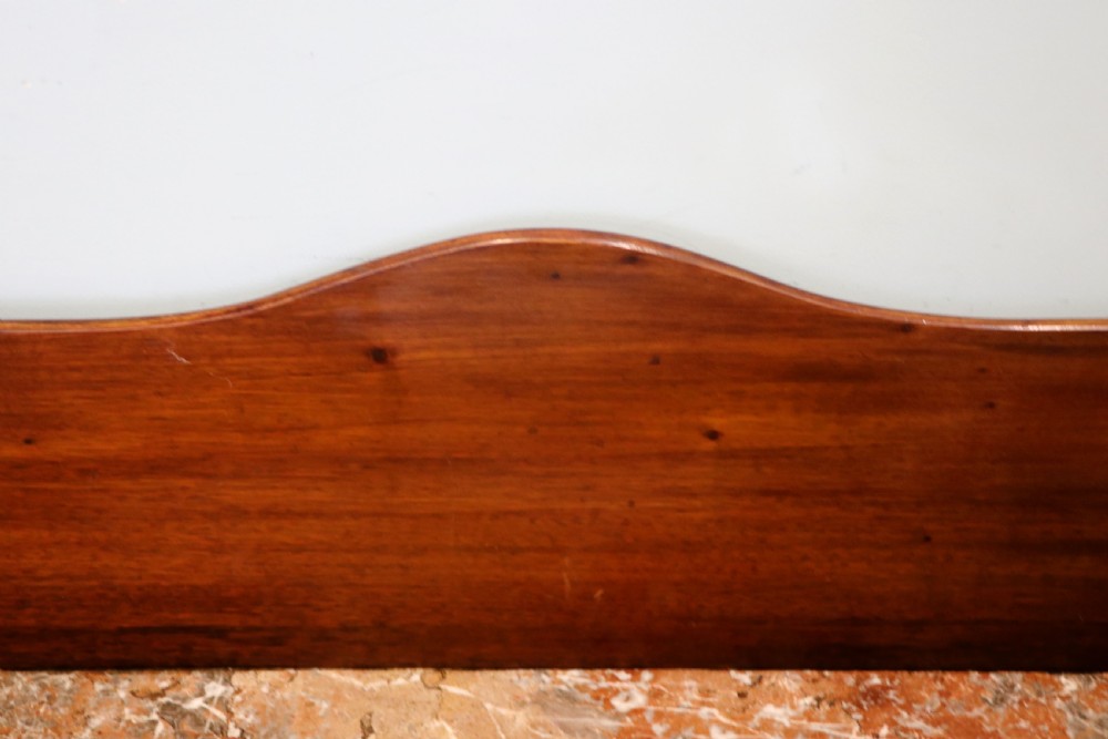 An Edwardian mahogany and satinwood washstand featuring a shaped marble top, wooden splashback, central drawer, and tapered legs on brass castors. View VII