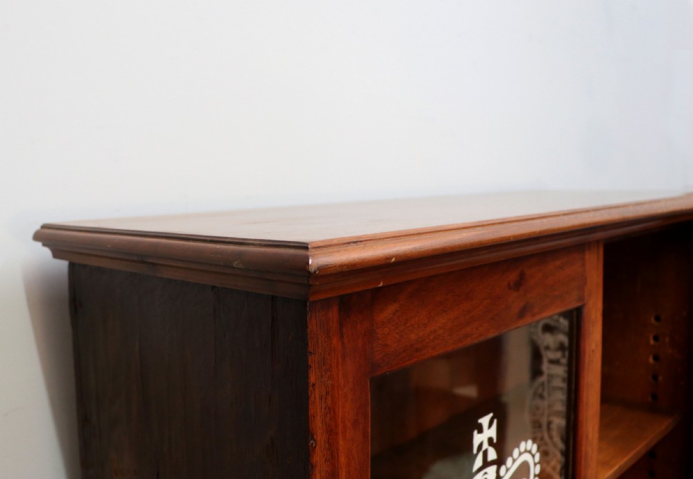 An early twentieth-century mahogany framed bookcase featuring two glazed doors decorated with the Home Office royal coat of arms stencil, supported on cabriole legs. View IV