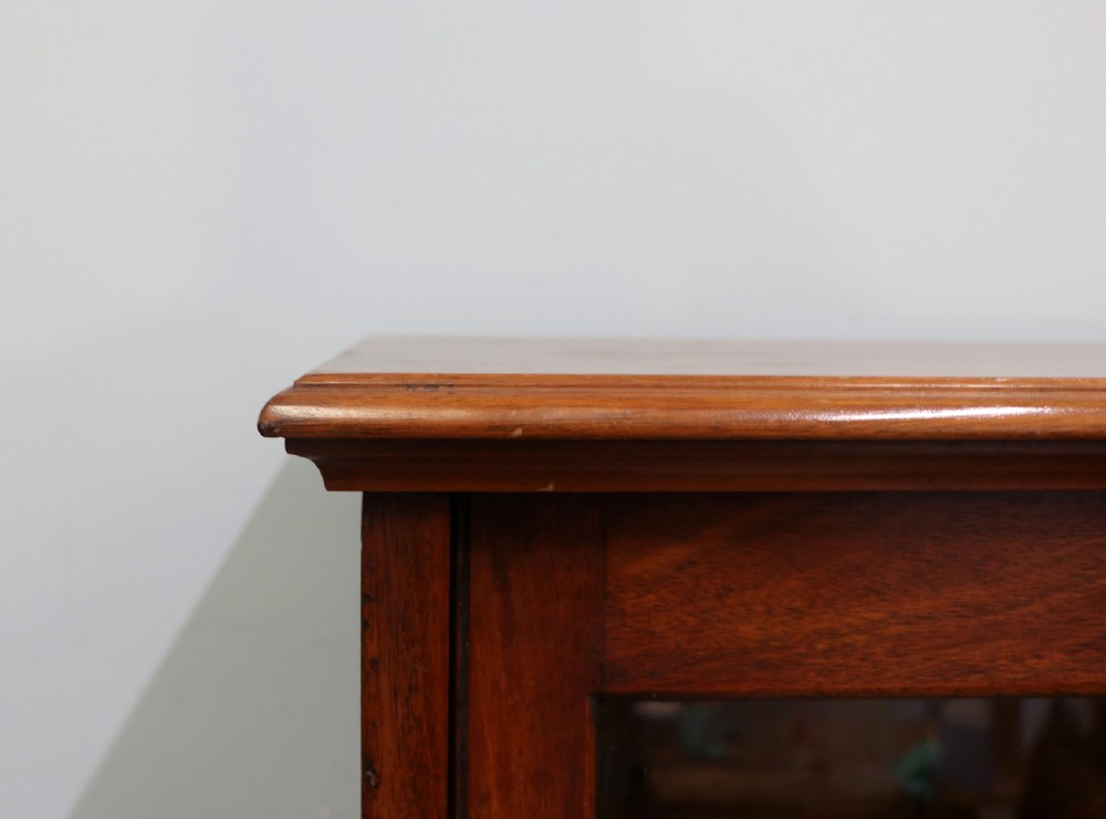 An early twentieth-century mahogany framed bookcase featuring two glazed doors decorated with the Home Office royal coat of arms stencil, supported on cabriole legs. View V