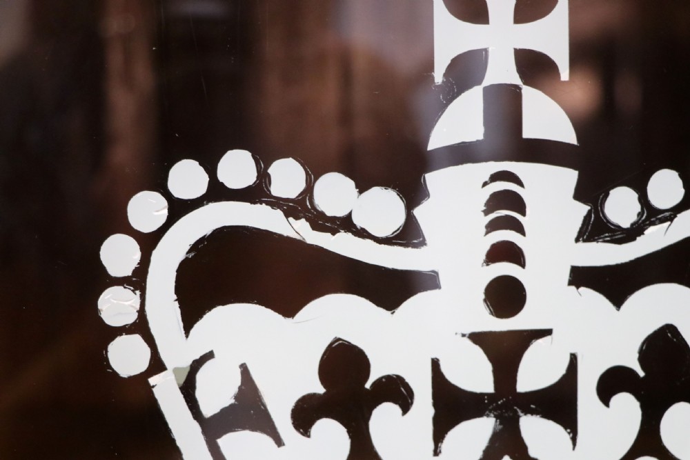 An early twentieth-century mahogany framed bookcase featuring two glazed doors decorated with the Home Office royal coat of arms stencil, supported on cabriole legs. View IX