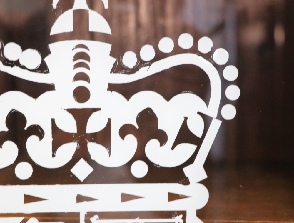 An early twentieth-century mahogany framed bookcase featuring two glazed doors decorated with the Home Office royal coat of arms stencil, supported on cabriole legs. View X