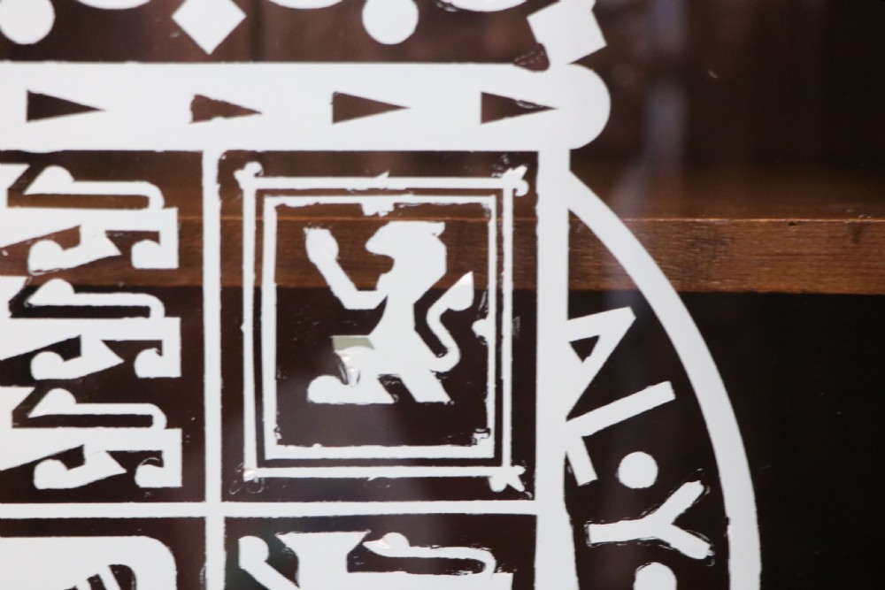An early twentieth-century mahogany framed bookcase featuring two glazed doors decorated with the Home Office royal coat of arms stencil, supported on cabriole legs. View XI